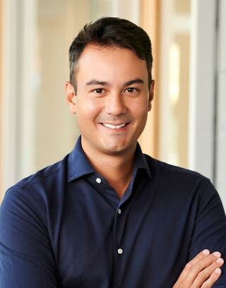 Alex Lim wearing a dress shirt with arms crossed