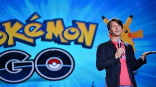 Man public speaking in front of a Pokemon backdrop